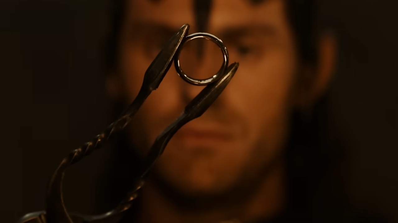 Sauron posmatra Jedan Prsten koji drži metalnim kleštima.